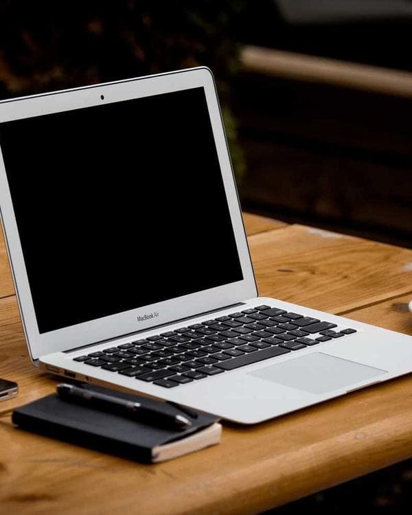 Laptop and notebook on a wooden desk